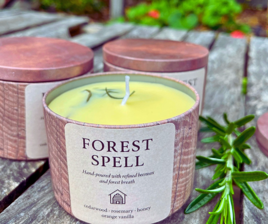 Candle labeled 'Forest Spell' with a wooden lid on a wooden surface.