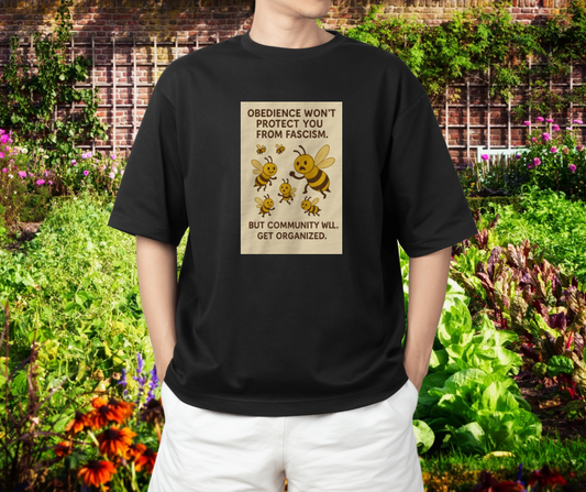 Person wearing a black t-shirt with a graphic and text in a garden setting