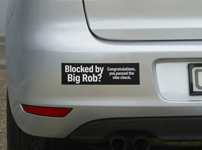 Bumper sticker on a car reading 'Blocked by Big Rob? Congratulations you passed the vibe check.'