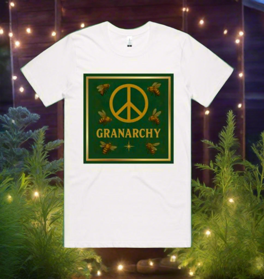 White t-shirt with 'Peace Granarchy' design featuring bees and a peace symbol on a green background, set against a blurred natural background with lights.