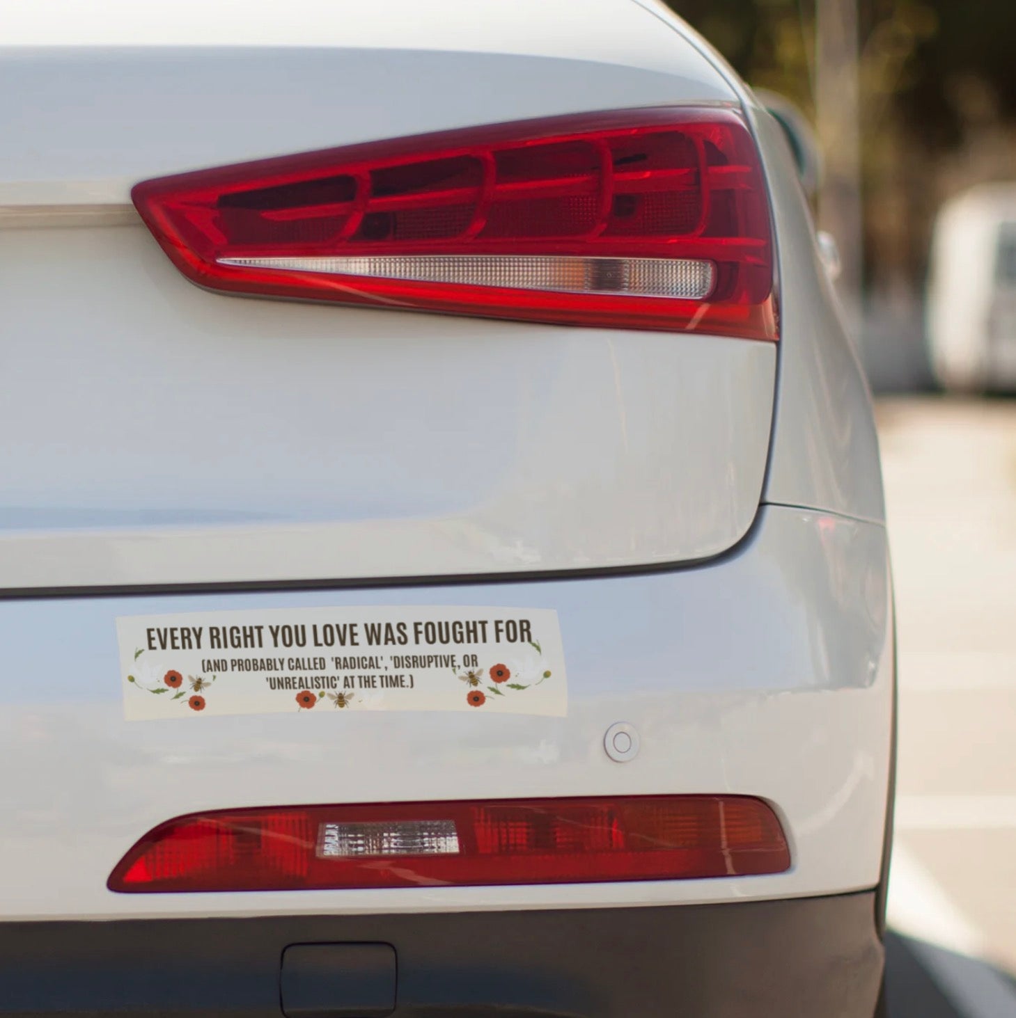 Car's rear with a bumper sticker on a blurred background