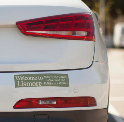 Car tail light with a humorous bumper sticker on a blurred background