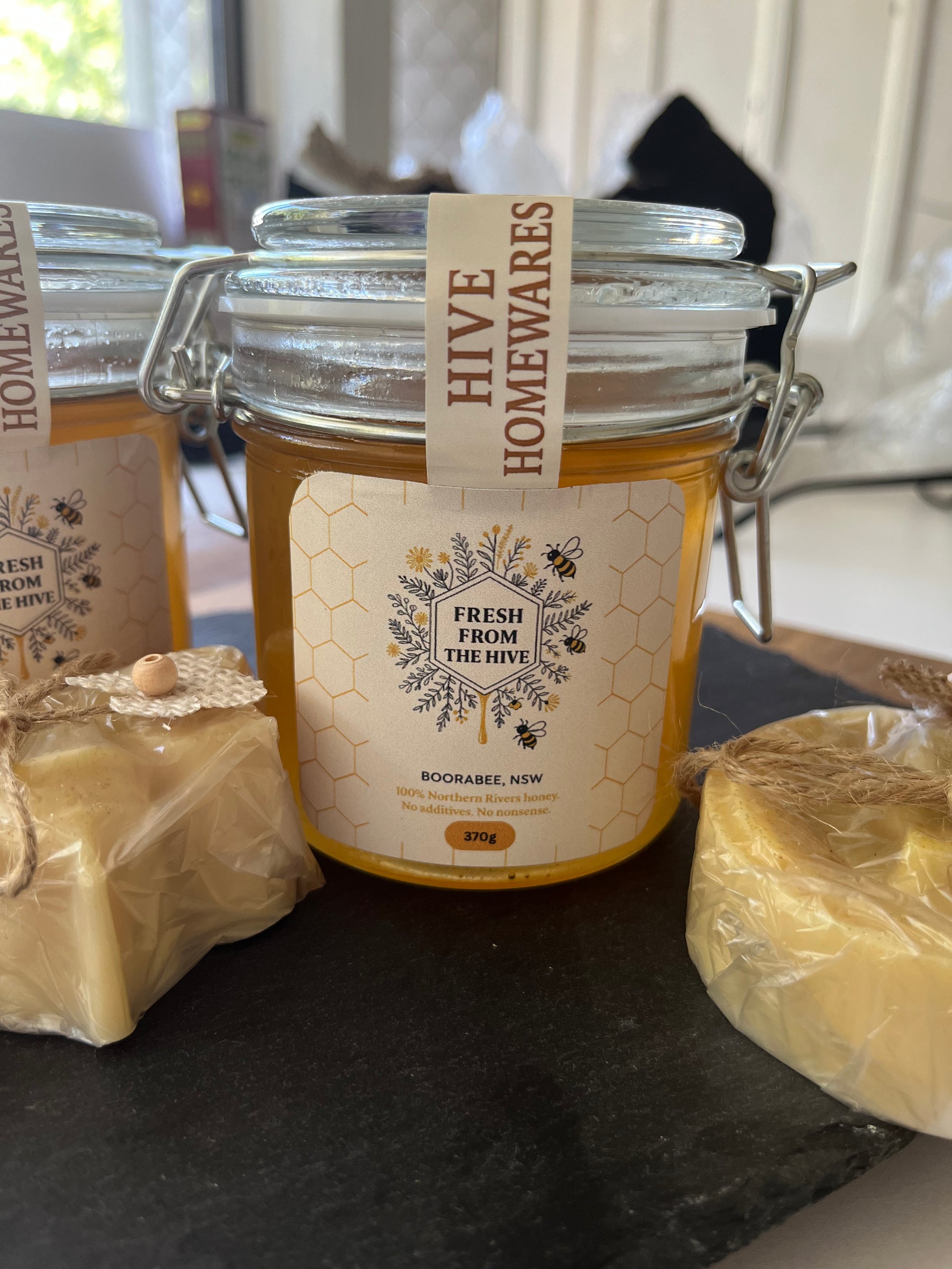 Hive Homewares honey jar with a label on a dark surface