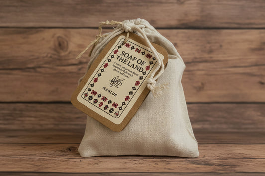 Bar of soap with a 'Soap of the Land' label on a beige fabric background