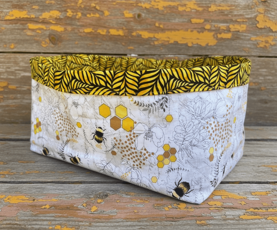 Large tote bag handmade from the Lazy Daisy Collection, featuring floral and bee patterns with a yellow lining.