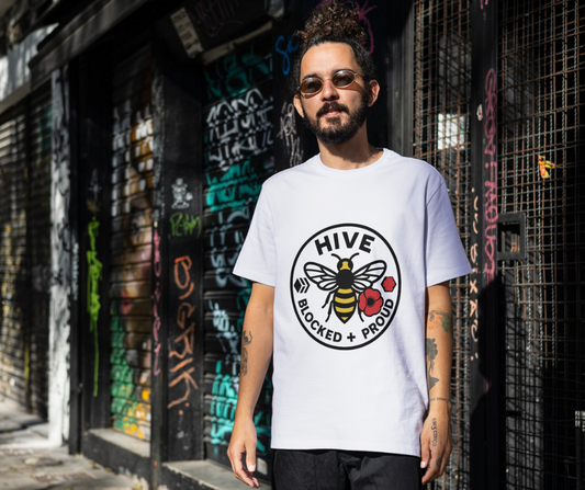 Man wearing a white t-shirt with a bee and flower graphic in an urban setting